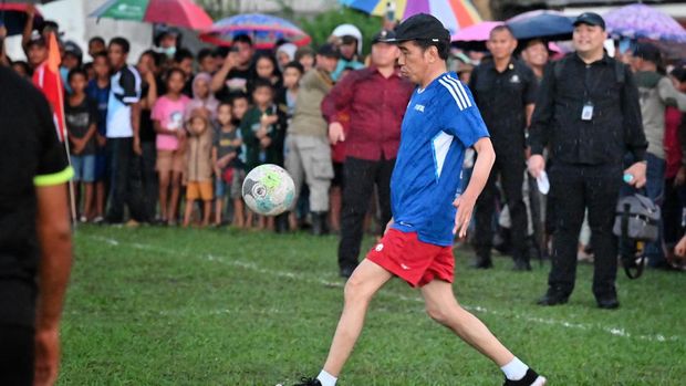 Presiden Jokowi bermain sepak bola mengenakan kaos bernomor 22 di Manggarai Barat, Nusa Tenggara Timur, Senin (4/12).