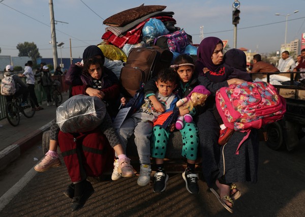 Women with children sit in a trailer, as Palestinians flee their houses due to Israeli strikes, after a temporary truce between Hamas and Israel expired, in the eastern part of Khan Younis in the southern Gaza Strip, December 1, 2023. REUTERS/Ibraheem Abu Mustafa