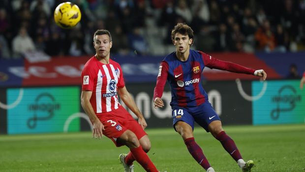Barcelona's Joao Felix, right, shoots on target as Atletico Madrid's Cesar Azpilicueta challenges during the Spanish La Liga soccer match between Barcelona and Atletico Madrid at the Olimpic Lluis Companys stadium in Barcelona, Spain, Sunday, Dec. 3, 2023. (AP Photo/Joan Monfort)
