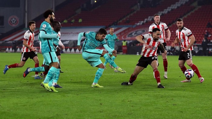 Liverpools Brazilian midfielder Roberto Firmino (C) scores his teams second goal during the English Premier League football match between Sheffield United and Liverpool at Bramall Lane in Sheffield, northern England on February 28, 2021. (Photo by LEE SMITH / POOL / AFP) / RESTRICTED TO EDITORIAL USE. No use with unauthorized audio, video, data, fixture lists, club/league logos or live services. Online in-match use limited to 120 images. An additional 40 images may be used in extra time. No video emulation. Social media in-match use limited to 120 images. An additional 40 images may be used in extra time. No use in betting publications, games or single club/league/player publications. /