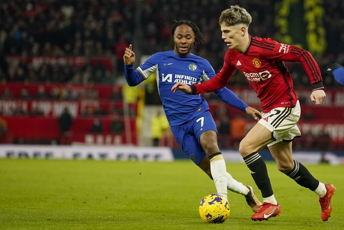 Manchester Uniteds Alejandro Garnacho, right, duels for the ball with Chelseas Raheem Sterling during the English Premier League soccer match between Manchester United and Chelsea at Old Trafford stadium in Manchester, England, Wednesday, Dec. 6, 2023. (AP Photo/Dave Thompson)