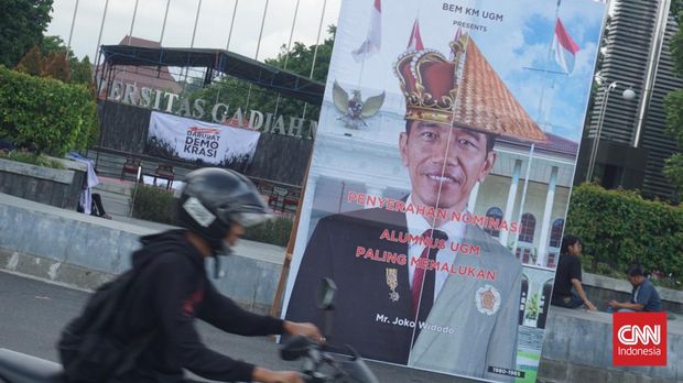 Banner besar Penyerahan Nominasi Alumnus UGM Paling Memalukan' dan bergambar Presiden Joko Widodo (Jokowi) terpampang di depan kampus UGM Sleman, Jumat (8/12).