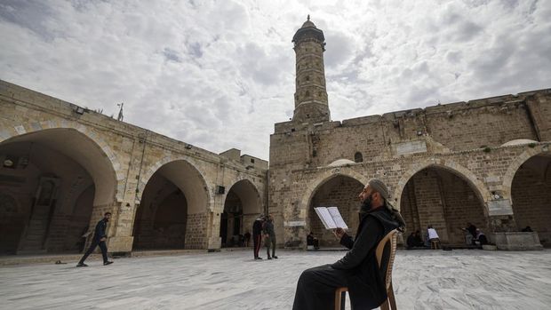 A Palestinian man reads the Koran at the Great Omari Mosque in Gaza City on the first day of the Muslim holy month of Ramadan on March 23, 2023. (Photo by MOHAMMED ABED / AFP)