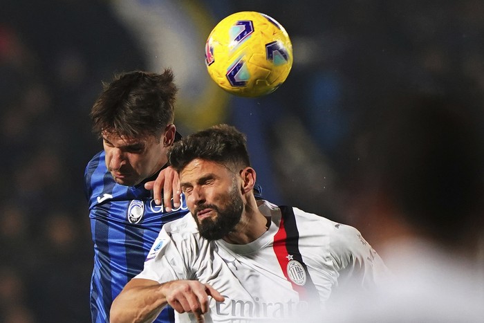 AC Milans Olivier Giroud, right, heads the ball during the Italian Serie A soccer match between Atalanta and AC Milan, at the Gewiss Stadium in Bergamo, Italy, Saturday, Dec. 9, 2023. (Spada/LaPresse via AP)