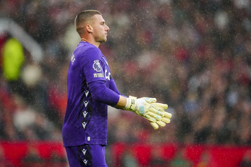 Crystal Palace's goalkeeper Sam Johnstone adjusts his gloves during the English Premier League soccer match between Manchester United and Crystal Palace at the Old Trafford stadium stadium in Manchester, England, Saturday, Sept. 30, 2023. (AP Photo/Jon Super)