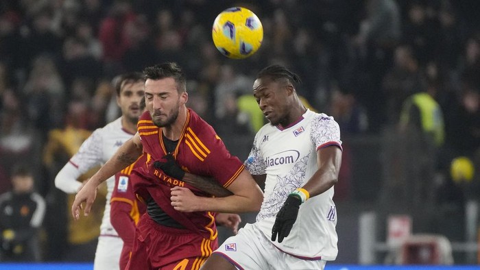 Romas Bryan Cristante, left, challenges for the ball with Fiorentinas Christian Kouame during the Series A soccer match between Roma and Fiorentina at the Romes Olympic stadium, Sunday, Dec. 10, 2023. (AP Photo/Gregorio Borgia)