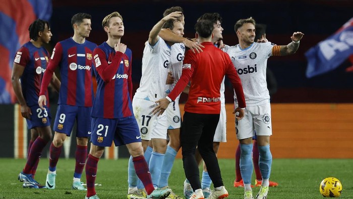 Gironas team players, right, celebrate after the Spanish La Liga soccer match between Barcelona and Girona at the Olimpic Lluis Companys stadium in Barcelona, Spain, Sunday, Dec. 10, 2023. (AP Photo/Joan Monfort)