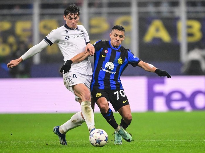 Real Sociedads French defender #24 Robin Le Normand fights for the ball with Inter Milans Chilean forward #70 Alexis Sanchez during the UEFA Champions League 1st round day 6 Group D football match between Inter Milan and Real Sociedad at the San Siro stadium in Milan on December 12, 2023. (Photo by Marco BERTORELLO / AFP)