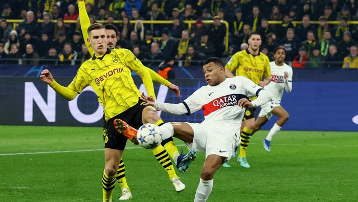 Soccer Football - Champions League - Group F - Borussia Dortmund v Paris St Germain - Signal Iduna Park, Dortmund, Germany - December 13, 2023 Paris St Germains Kylian Mbappe in action with Borussia Dortmunds Nico Schlotterbeck REUTERS/Wolfgang Rattay