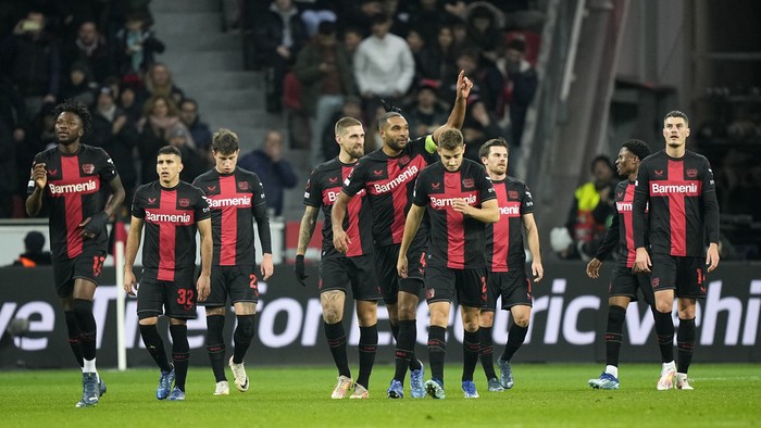 Leverkusens Jonathan Tah, center, shows thumbs up after Leverkusens Edmond Tapsoba, left, scored the second goal during the Europa League Group H soccer match between Bayer Leverkusen and Molde FK at the BayArena in Leverkusen, Germany, Thursday, Dec. 14 , 2023. (AP Photo/Martin Meissner)