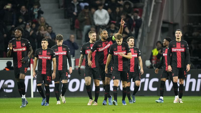 Leverkusen's Jonathan Tah, center, shows thumbs up after Leverkusen's Edmond Tapsoba, left, scored the second goal during the Europa League Group H soccer match between Bayer Leverkusen and Molde FK at the BayArena in Leverkusen, Germany, Thursday, Dec. 14 , 2023. (AP Photo/Martin Meissner)