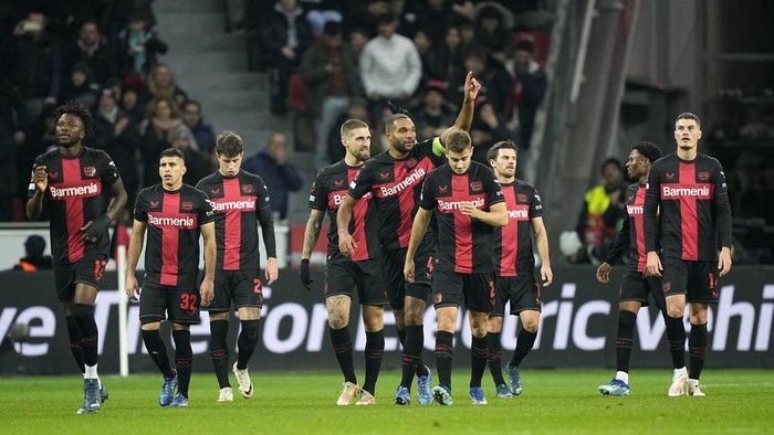Leverkusens Jonathan Tah, center, shows thumbs up after Leverkusens Edmond Tapsoba, left, scored the second goal during the Europa League Group H soccer match between Bayer Leverkusen and Molde FK at the BayArena in Leverkusen, Germany, Thursday, Dec. 14 , 2023. (AP Photo/Martin Meissner)