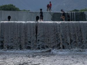 Potret Anak-anak Palu Bermain Air di Dam Pengendali Banjir