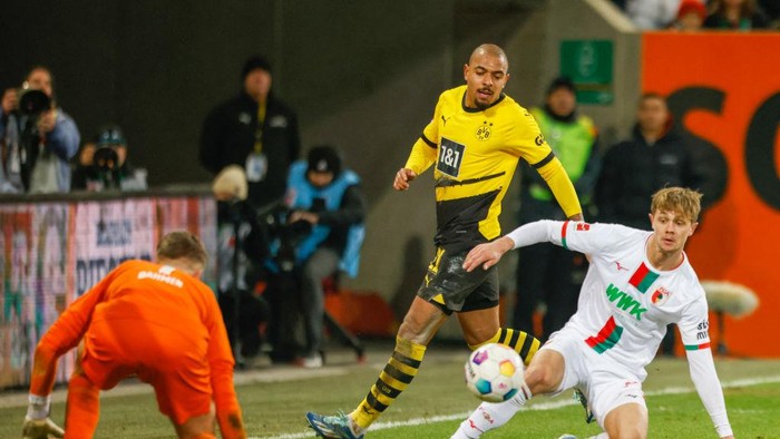 Dortmunds Dutch forward #21 Donyell Malen tries to score during the German first division Bundesliga football match between Augsburg and Borussia Dortmund in Augsburg on December 16, 2023. (Photo by MICHAELA REHLE / AFP) / DFL REGULATIONS PROHIBIT ANY USE OF PHOTOGRAPHS AS IMAGE SEQUENCES AND/OR QUASI-VIDEO (Photo by MICHAELA REHLE/AFP via Getty Images)