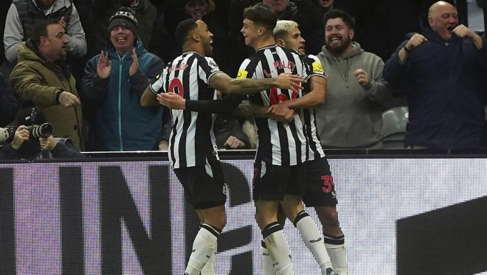 Newcastle Uniteds Lewis Miley, centre, celebrates scoring his sides first goal of the game, during the English Premier League soccer match between Newcastle United and Fulham, at St. James Park, in Newcastle upon Tyne, England, Saturday, Dec. 16, 2023. (Owen Humphreys/PA via AP)