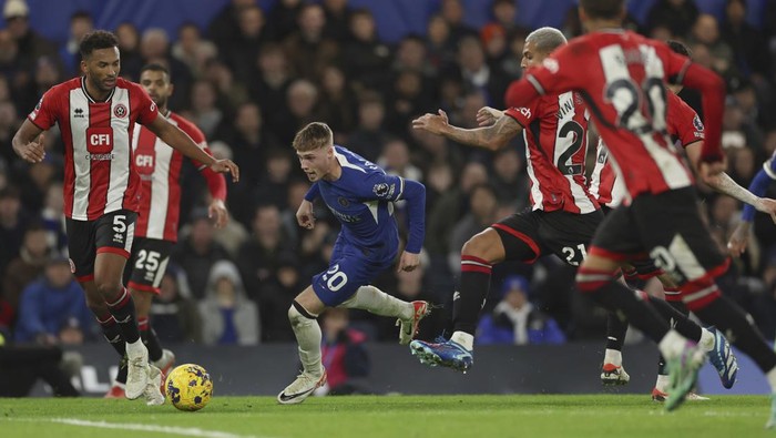 Chelseas Cole Palmer takes the ball forward as Sheffield Uniteds Auston Trusty, left goes to tackle during the English Premier League soccer match between Chelsea and Sheffield United at Stamford Bridge in London, Saturday, Dec. 16, 2023. (AP Photo/Ian Walton)