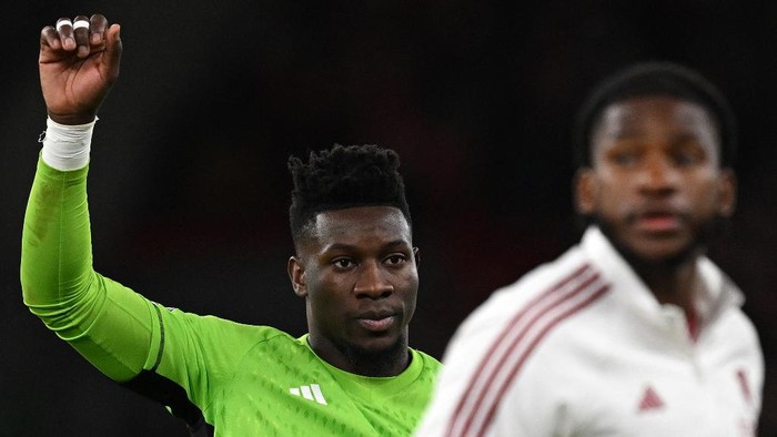 Manchester Uniteds Cameroonian goalkeeper #24 Andre Onana applauds the fans following the English Premier League football match between Liverpool and Manchester United at Anfield in Liverpool, north west England on December 17, 2023. (Photo by Paul ELLIS / AFP) / RESTRICTED TO EDITORIAL USE. No use with unauthorized audio, video, data, fixture lists, club/league logos or live services. Online in-match use limited to 120 images. An additional 40 images may be used in extra time. No video emulation. Social media in-match use limited to 120 images. An additional 40 images may be used in extra time. No use in betting publications, games or single club/league/player publications. /