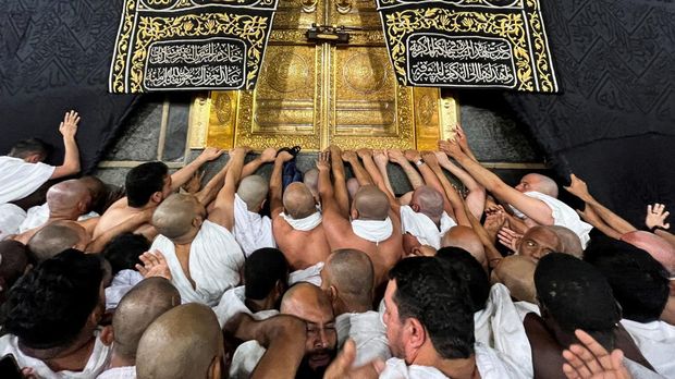 Muslims touch and pray at al-Hajr al-Aswad