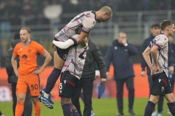 Bolognas Michel Aebischer, left, and Bolognas Nikola Moro celebrate at the end of the Italian Cup round of 16 soccer match between Inter Milan and Bologna, at the San Siro stadium in Milan, Italy, Wednesday, Dec. 20, 2023. (AP Photo/Luca Bruno)