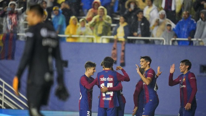 Barcelona players celebrate a goal by Lamine Yamal Nasraoui as Club America goalkeeper Luis Malagón, left, looks on during the first half of a club soccer friendly match, Thursday, Dec. 21, 2023, at the Cotton Bowl Stadium in Dallas. Club America won 3-2. (AP Photo/Julio Cortez)
