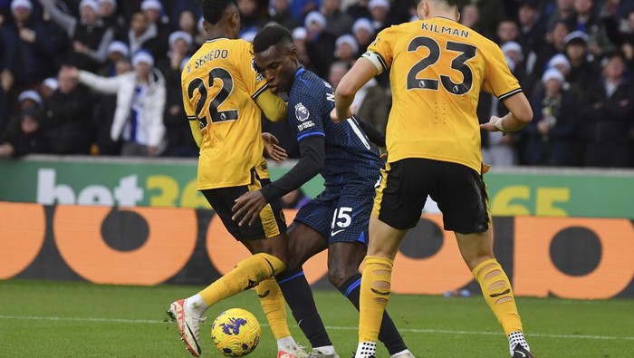 Chelseas Nicolas Jackson, centre, challenges for the ball with Wolverhampton Wanderers Nelson Semedo, left, and Wolverhampton Wanderers Max Kilman, right, during the English Premier League soccer match between Wolverhampton Wanderers and Chelsea at Molineux stadium in Wolverhampton, England, Sunday, Dec. 24, 2023. (AP Photo/Rui Vieira)
