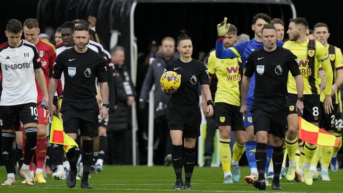 fulham vs burnley, wasit, rebecca welch Referee Rebecca Welch, center, leads the players on to the pitch for the English Premier League soccer match between Fulham and Burnley at Craven Cottage stadium in London, Saturday, Dec. 23, 2023. Welch is the first female referee ever to officiate an English Premier League game. (AP Photo/Alastair Grant)