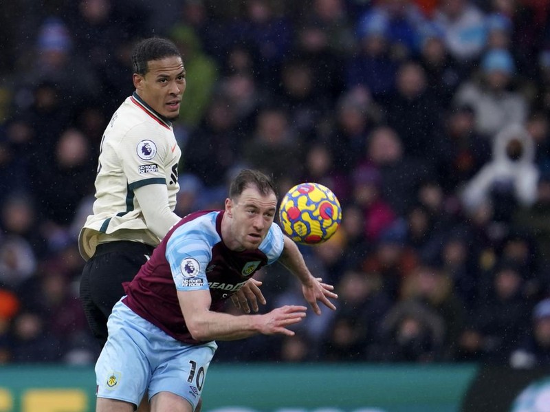 Liverpool's Virgil van Dijk, left, duels for the ball with Burnley's Ashley Barnes during the English Premier League soccer match between Burnley and Liverpool at Turf Moor, in Burnley, England, Sunday, Feb. 13, 2022. (AP Photo/Jon Super)