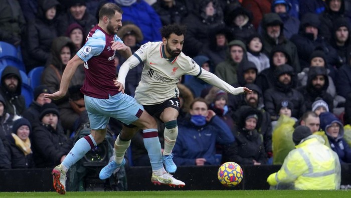 Liverpools Mohamed Salah, right, duels for the ball with Burnleys Erik Pieters during the English Premier League soccer match between Burnley and Liverpool at Turf Moor, in Burnley, England, Sunday, Feb. 13, 2022. (AP Photo/Jon Super)