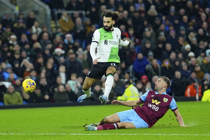 Burnleys Charlie Taylor, right, fights for the ball with Liverpools Mohamed Salah during the English Premier League soccer match between Burnley and Liverpool at Turf Moor stadium in Burnley, England, Tuesday, Dec. 26, 2023. (AP Photo/Jon Super)
