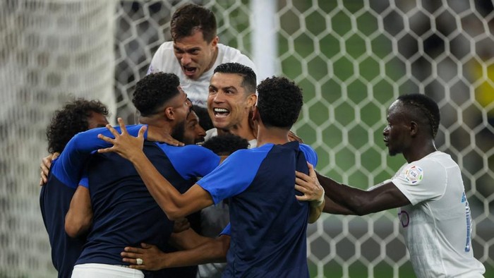 Nassrs Portuguese forward #07 Cristiano Ronaldo (3rd-R) celebrates his second goal with his team during the Saudi Pro League football match between Al-Ittihad and Al-Nassr at King Abdullah Sports City Stadium in Jeddah on December 26, 2023. (Photo by AFP)