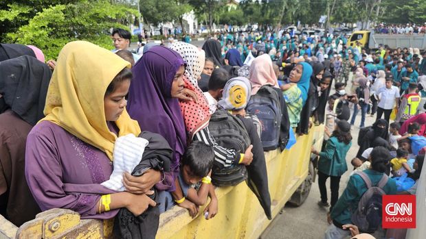 Ratusan massa yang tergabung dalam mahasiswa tolak pengungsi Rohingya mengangkut paksa imigran gelap tersebut dari tempat penampungan sementara di Gedung Balee Meuseuraya Aceh (BMA) untuk dipindah ke kantor Kemenkumham Aceh, Rabu (27/12). CNN Indonesia/Dani Randi