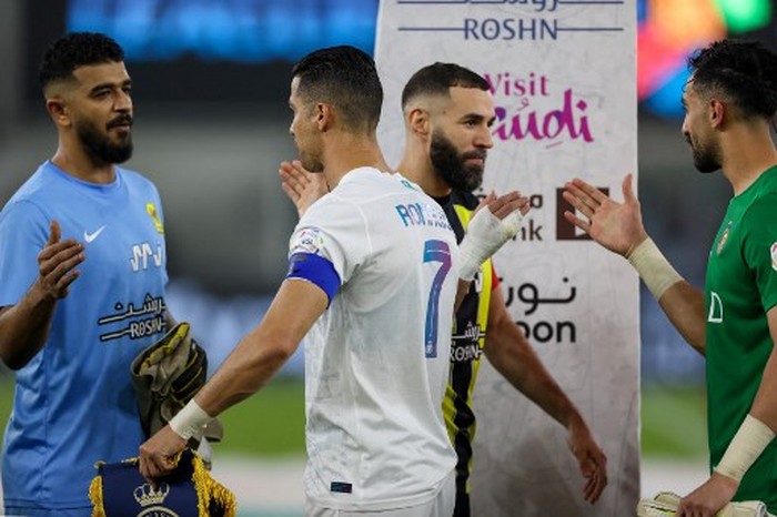 Nassrs Portuguese forward #07 Cristiano Ronaldo (C-left) and Ittihads French forward #09 Karim Benzema (C-right) greet players ahead of the Saudi Pro League football match between Al-Ittihad and Al-Nassr at King Abdullah Sports City Stadium in Jeddah on December 26, 2023. (Photo by AFP)