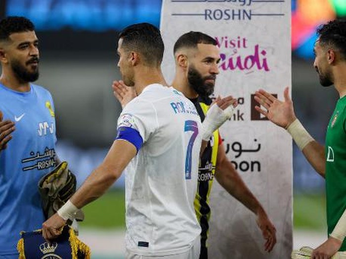 Nassr's Portuguese forward #07 Cristiano Ronaldo (C-left) and Ittihad's French forward #09 Karim Benzema (C-right) greet players ahead of the Saudi Pro League football match between Al-Ittihad and Al-Nassr at King Abdullah Sports City Stadium in Jeddah on December 26, 2023. (Photo by AFP)