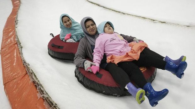 Wisata Libur Natal di Trans Snow World Bintaro People go snow tubing on artificial snow at Trans Snow World Bintaro, an indoor snow park with a Japanese theme, in Bintaro on December 27, 2023. (Photo by Yasuyoshi CHIBA / AFP)