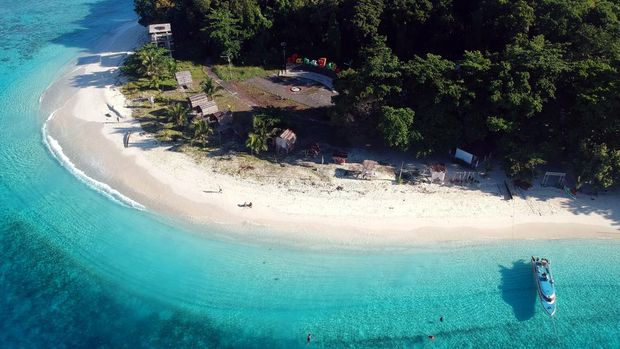 Wisatawan menikmati keindahan alam Pantai Pulau Sara, Kabupaten Kepulauan Talaud, Sulawesi Utara, Jumat (29/12/2023). Pulau Sara merupakan kawasan paling utara di Indonesia timur yang berbatasan langsung dengan wilayah Davao dan Mindanao, Filipina, dan menjadi salah satu destinasi wisata andalan Kabupaten Kepulauan Talaud pada libur akhir tahun yang menawarkan pesona keindahan alam bagi para wisatawan. ANTARA FOTO/Yulius Satria Wijaya/aww.