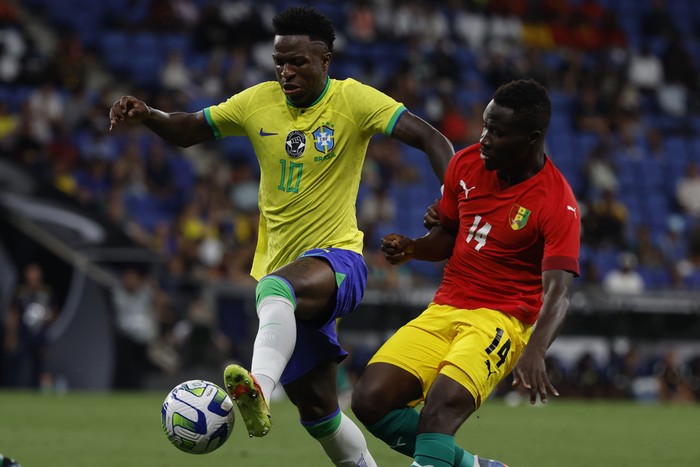 Brazils Vinicius Junior, left, is challenged by Guineas Morlaye Sylla during an international friendly soccer match between Brazil and Guinea at the RCDE Stadium in Barcelona, Spain, Saturday, June 17, 2023. (AP Photo/Joan Monfort)