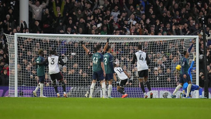 Fulhams Bobby De Cordova-Reid (14), center, scores his sides second goal during the English Premier League soccer match between Arsenal and Fulham at Craven Cottage stadium in London, Sunday, Dec. 31, 2023. (AP Photo/Alastair Grant)