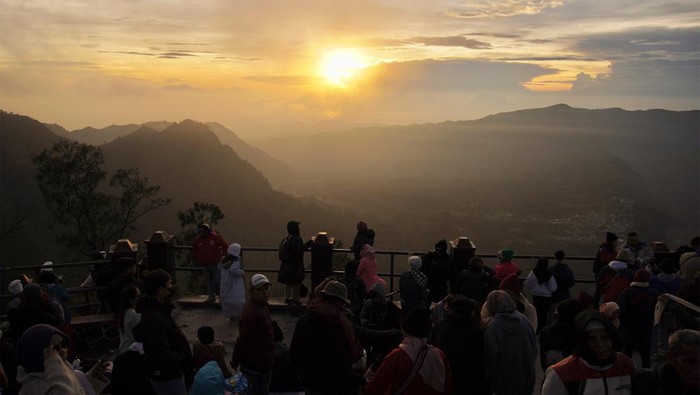 Seorang turis mengabadikan gambar matahari terbit di Penanjakan Satu Bromo, Pasuruan, Jawa Timur, Senin (1/1/2024). Kawasan Taman Nasional Bromo Tengger Semeru (TNBTS) ramai dikunjungi turis yang sengaja tiba untuk menyaksikan matahari terbit pertama di tahun 2024. ANTARA FOTO/Irfan Sumanjaya/Spt.