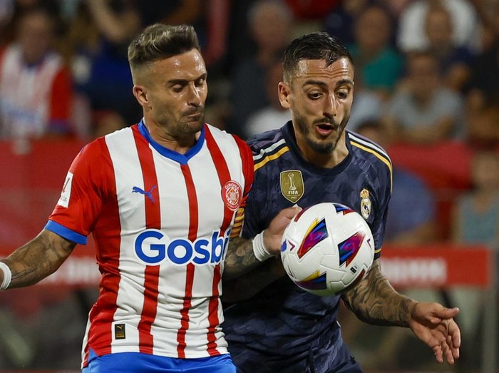 Girona's Aleix Garcia, left, duels for the ball with Real Madrid's Joselu during a Spanish La Liga soccer match between Girona and Real Madrid, at the Montilivi stadium in Girona, Spain, Saturday, Sept. 30, 2023. (AP Photo/Joan Monfort)