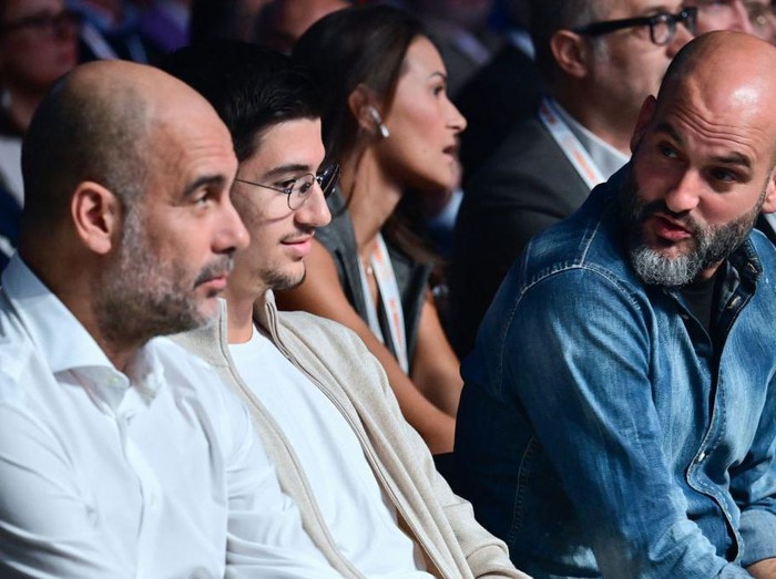 Manchester City Spanish head coach Josep Guardiola (L) sits next to his son Marcus Guardiola (C), as he listens to his brother Pere Guardiola (R), before addressed students during the conference 