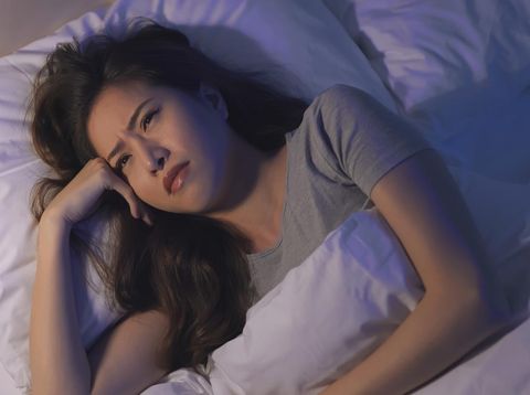 close up of asian woman lose sleep on the bed at night