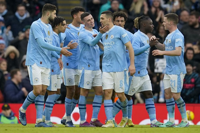 Manchester Citys Phil Foden celebrates with teammates after scoring his sides fourth goal during the English FA Cup third round soccer match between Manchester City and Huddersfield Town, at the Etihad stadium in Manchester, England, Sunday, Jan. 7, 2024. (AP Photo/Dave Thompson)