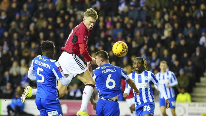 Manchester Uniteds Scott McTominay, second left, heads the ball ahead of Wigan Athletics Charlie Hughes during the English FA Cup third round soccer match between Wigan Athletic and Manchester United at the DW Stadium, Wigan, England, Monday, Jan. 8, 2024. (AP Photo/Jon Super)