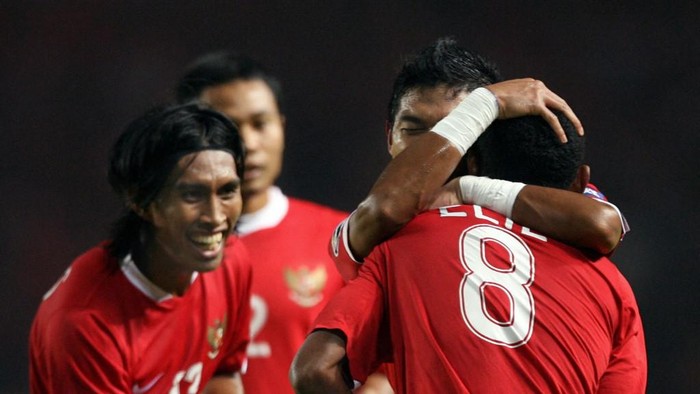 (CORRECTION) Indonesian player Bambang Pamungkas hugs Elie Aiboy (8) as Budi Sudarsono (L) smiles to celebrate a score for Indonesia during their Asian Cup 2007 Group D football match at the Bung Karno stadium in Jakarta, 14 July 2007. The score is 1-1 as the match continues. AFP PHOTO/Adek Berry (Photo by ADEK BERRY / AFP)