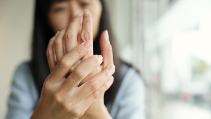 Woman suffering from wrist pain, numbness, or Carpal tunnel syndrome hand holding her ache joint