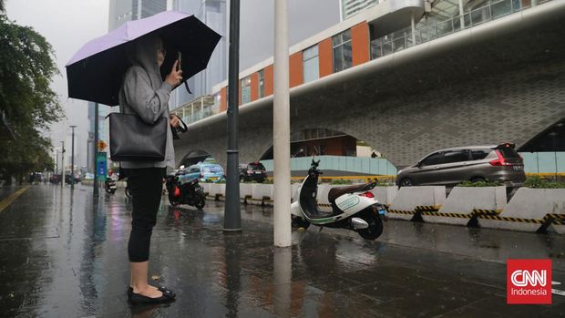 Warga kehujanan saat hujan deras dan angin di kawasan MH Thamrin, Jakarta, Kamis, 11 Januari 2024. Sebagian besar wilayah DKI Jakarta diguyur hujan deras, Kamis (11/1/2024) siang. Di Jakarta Pusat, hujan mulai turun sekitar pukul 13.00 WIB dan masih berlangsung hingga 14.21 WIB. (CNN Indonesia/Safir Makki)