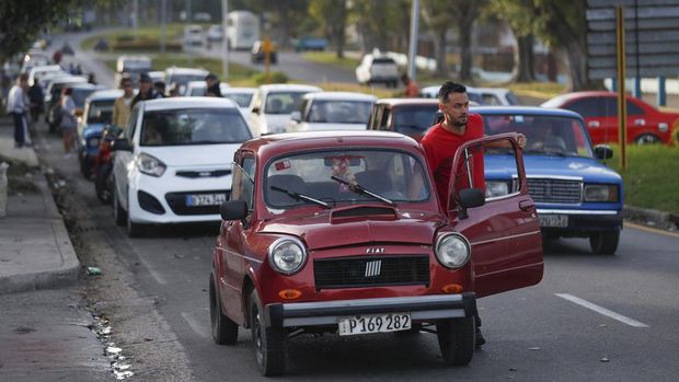 A man pushes his car while waiting along with others to fill up at a gas station, as the government announced it will hike the retail price of its 94 octane gasoline from 30 to 156 pesos per litre beginning February 1, in Havana, Cuba January 9, 2024. REUTERS/Yander Zamora