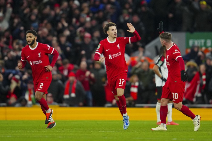 Liverpools Curtis Jones, center, celebrates after scoring his sides opening goal during the EFL Cup first leg semi final soccer match between Liverpool and Fulham at Anfield stadium in Liverpool, England, Wednesday, Jan. 10, 2024. (AP Photo/Jon Super)