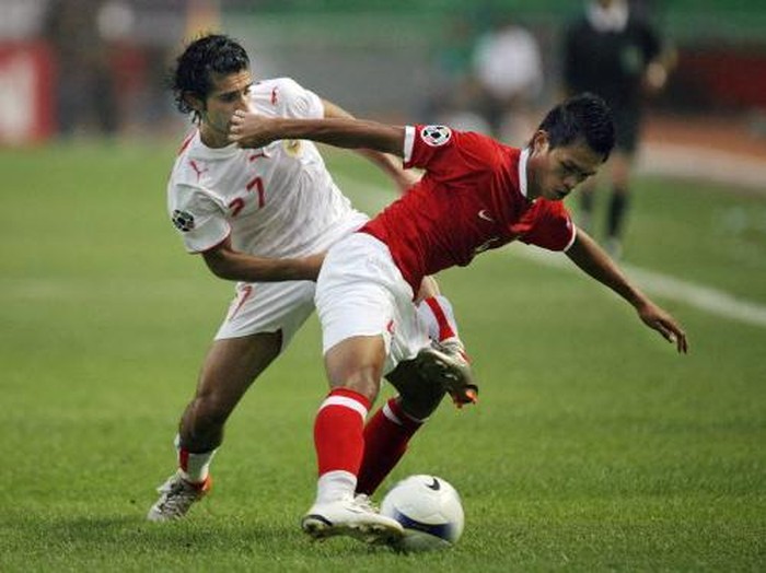 Bahrains Mahmood Abdul Rahman (L) fights for the ball with Indonesian Richardo Salampessy during the Asian Cup 2007 Group D football match at the Bung Karno stadium in Jakarta, 10 July 2007. The first half ended in a draw 1-1.  AFP PHOTO/Bay ISMOYO (Photo by BAY ISMOYO / AFP)
