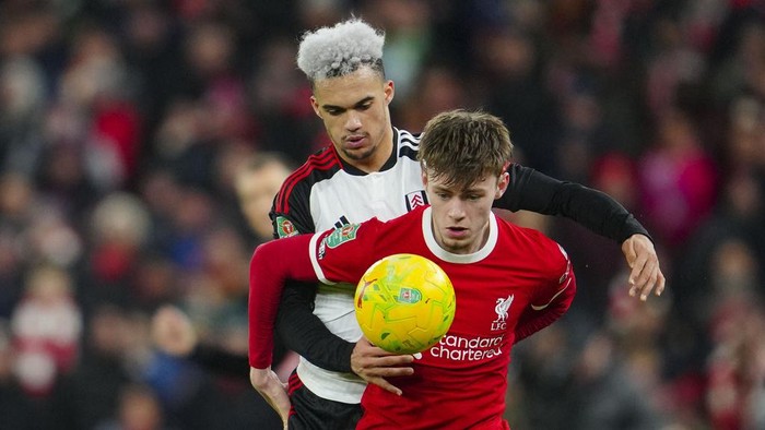 Liverpools Conor Bradley, front, duels for the ball with Fulhams Antonee Robinson during the EFL Cup first leg semi final soccer match between Liverpool and Fulham at Anfield stadium in Liverpool, England, Wednesday, Jan. 10, 2024. (AP Photo/Jon Super)